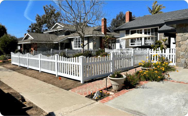 Front yard with white vinyl fencing in a square formation