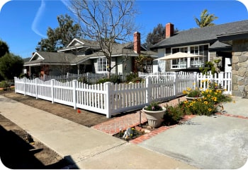 smaller crop of front yard with white vinyl fencing in a square formation